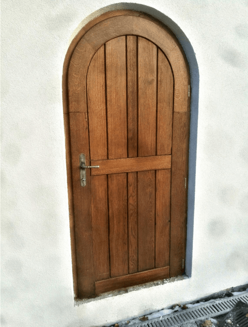 Masivní dubové dveře s obloukem, natřeny lazurou